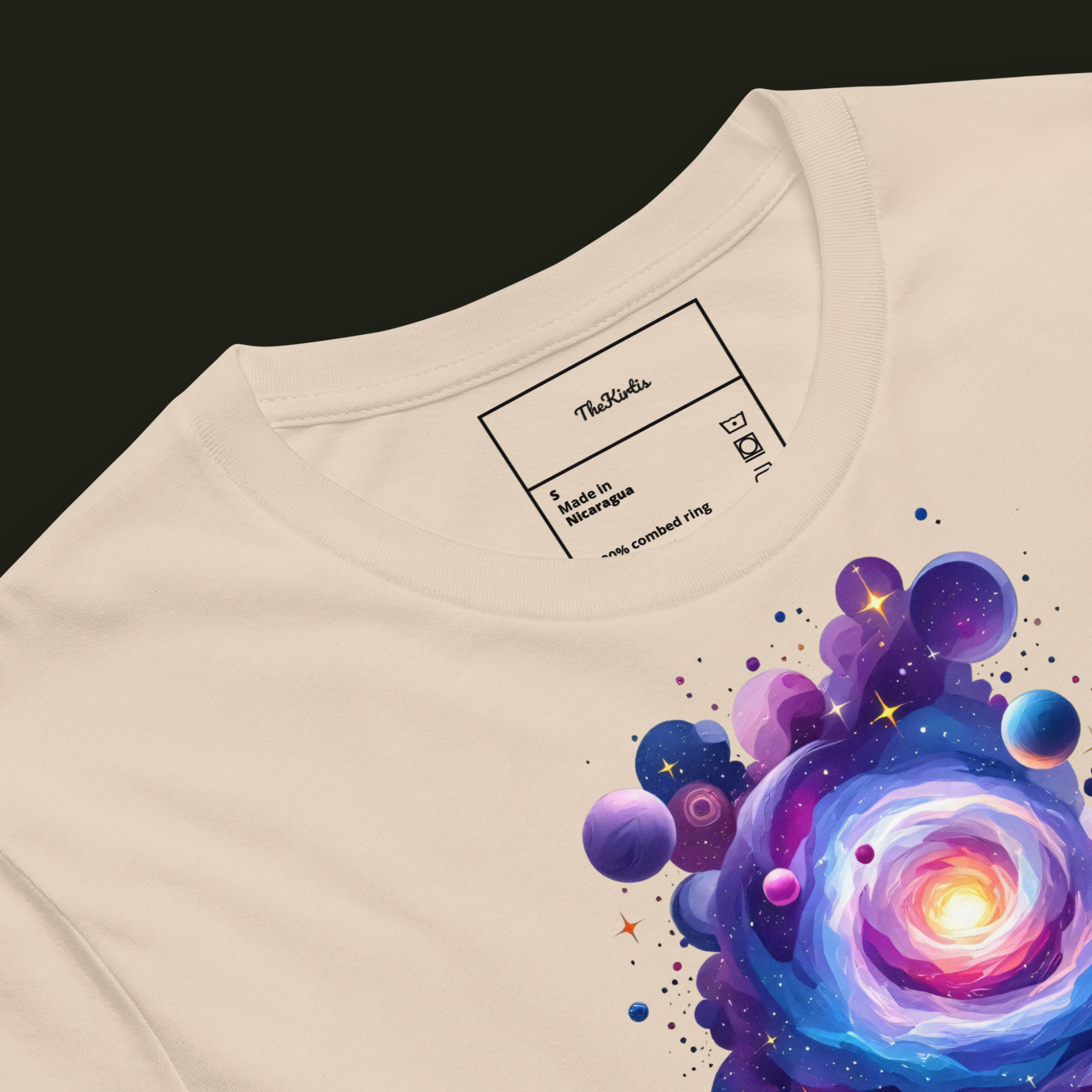 Close-up of the Cosmic Threshold artwork on a soft cream unisex t-shirt highlighting the luminous galaxy, surrounding planets and intricate cosmic details.
