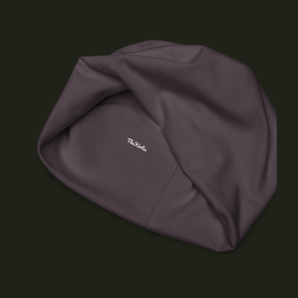 Inside view of the Myrqalen unisex beanie showing the TheKirtis label, muted mauve taupe fabric texture and interior seam construction.