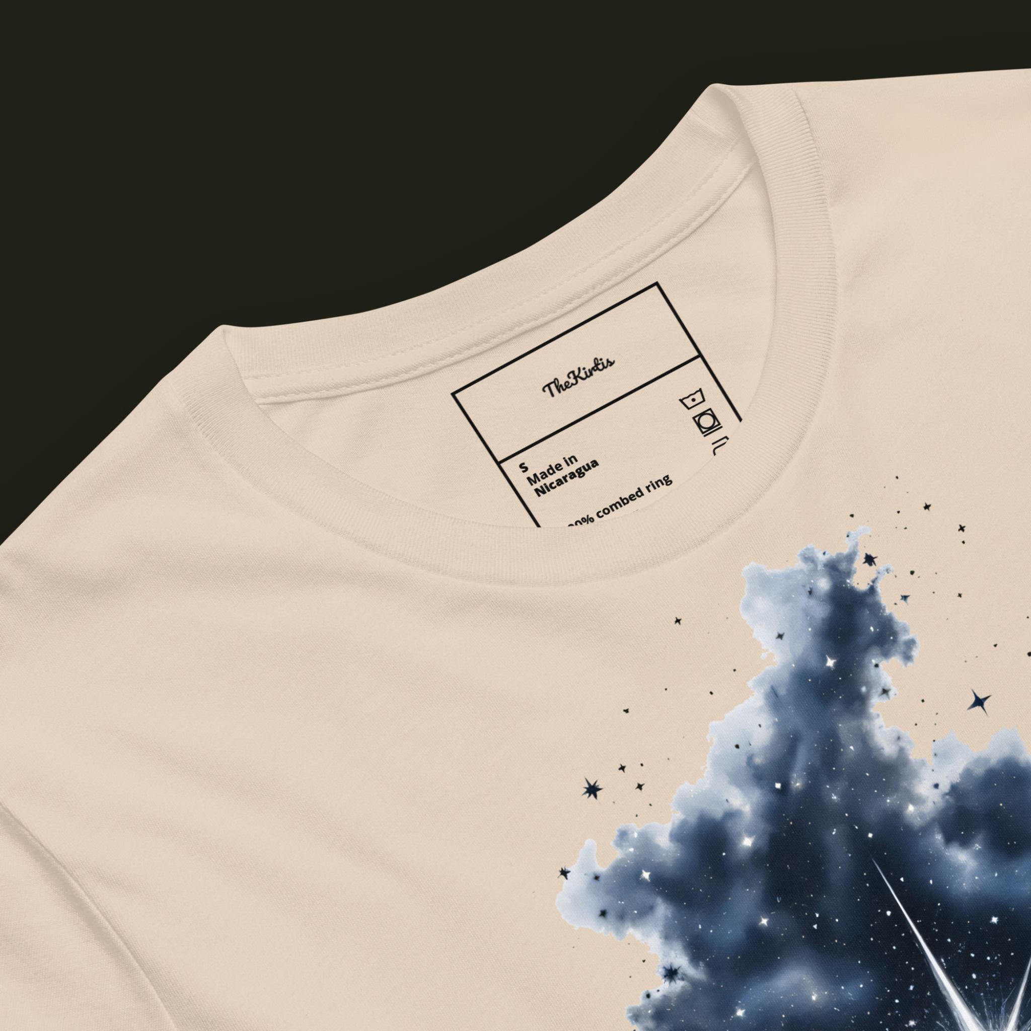 Close-up of the Within the Darkness artwork on a soft cream unisex t-shirt highlighting the dark nebula texture and scattered stars.